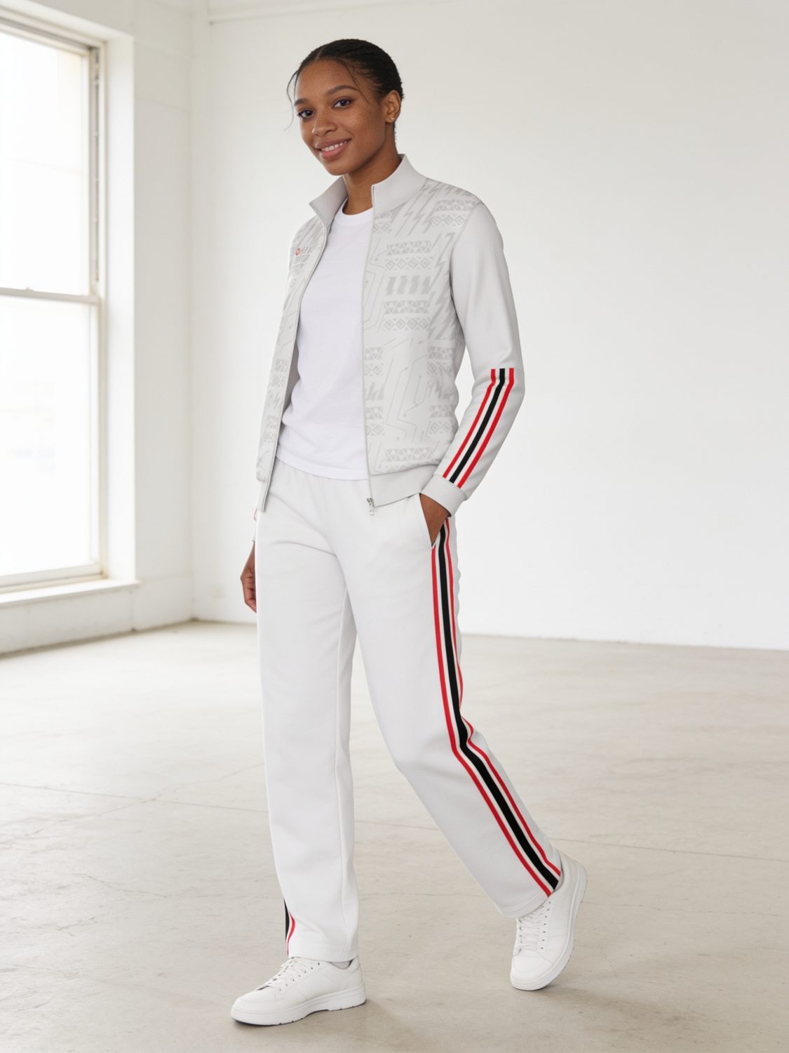 A woman in a white zip-up tracksuit jacket and striped track pants