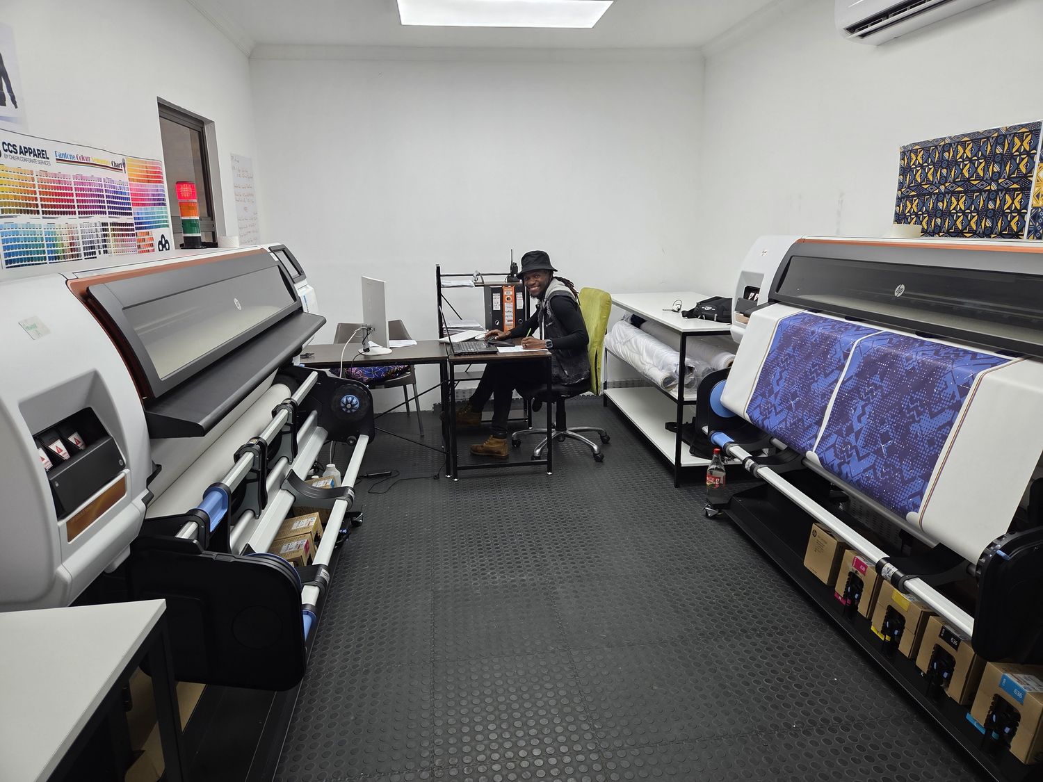 A large-format sublimation printer printing a blue pattern onto fabric