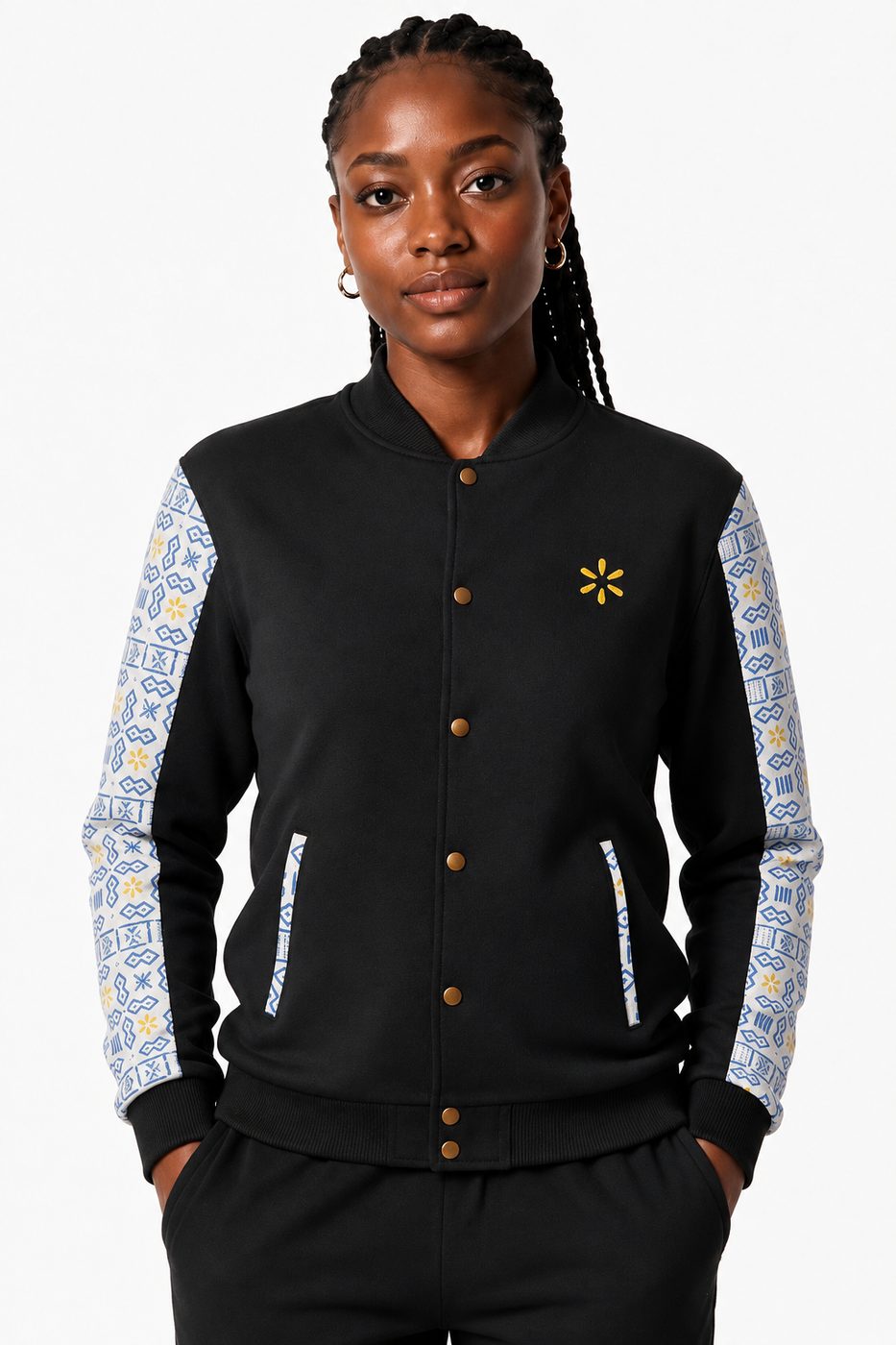 A woman in a black varsity jacket with patterned light blue sleeves and a yellow spark on the chest