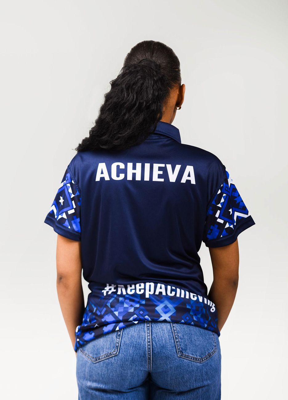 The back of a navy golf shirt reading ACHIEVA with print sleeves