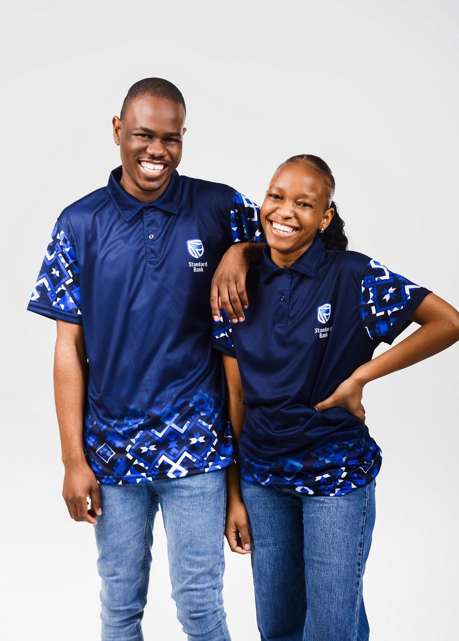 Two smiling people in navy golf shirts with blue print sleeves