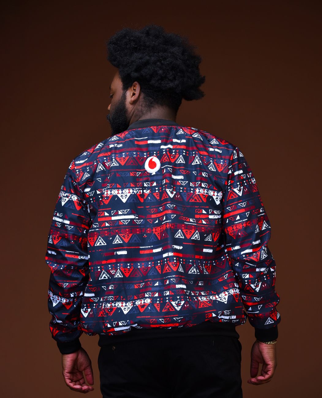 The back of a red, white and navy print bomber jacket